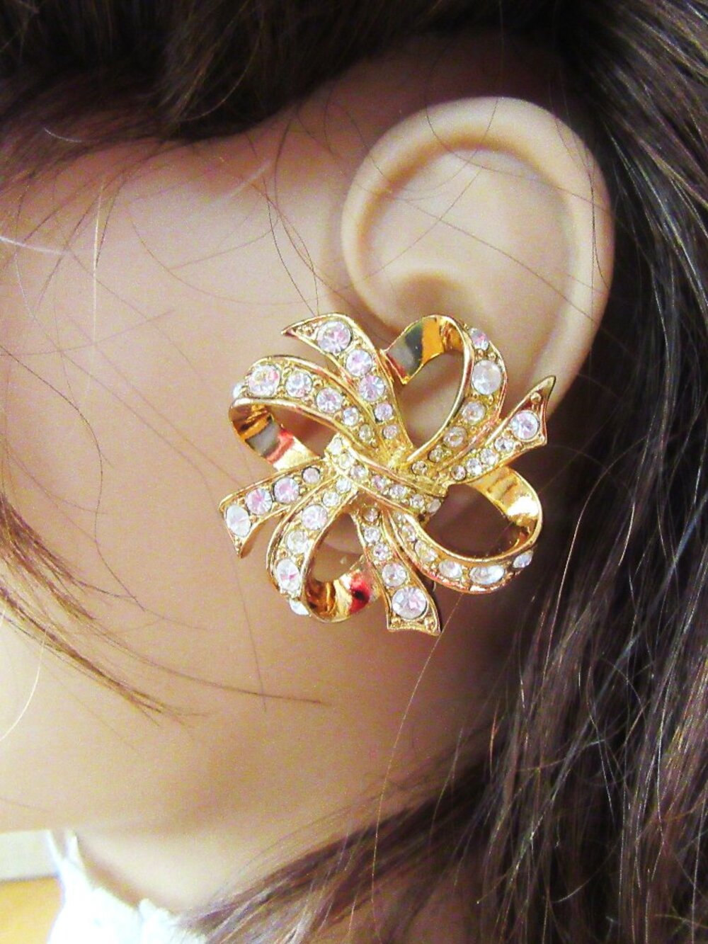 KJL for Avon (Kenneth Jay Lane) gold ribbon clip earrings with clear rhinestones